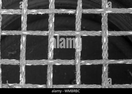 Black and White image of close up of nylon safety netting in an entertainment area to protect children. Lovely textures with speckled contrast. Stock Photo