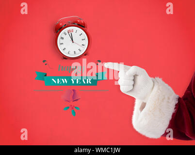 Santa Claus points at something against red background Stock Photo