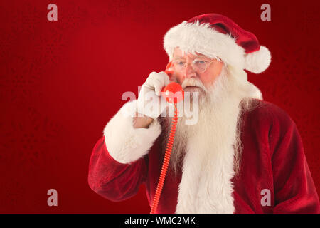 Santa on his red phone against red background Stock Photo