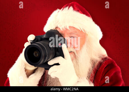 Santa is taking a picture against red background Stock Photo