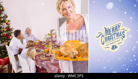 Proud mother showing roast turkey against purple vignette Stock Photo