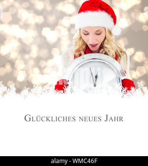 happy festive blonde with clock against christmas greeting in german Stock Photo