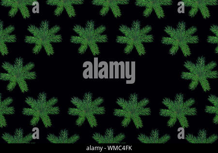Christmas frame made of natural green fir tree branches as snowflakes on black background. Stock Photo