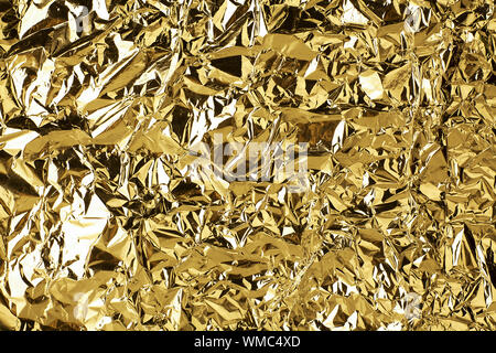 Crumpled golden foil shining texture background, bright shiny gold luxury design, metallic glitter surface, holiday decoration backdrop concept, gold Stock Photo
