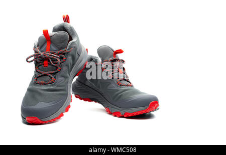 Men trekking shoes isolated on white background. Gray-red hiking shoes. Safety footwear for climbing. Adventure gear. Lightweight rubber trekking shoe Stock Photo