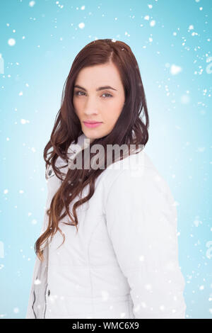 Beauty brown hair in white coat posing  against blue background with vignette Stock Photo