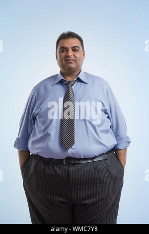 Portrait of obese man in formal clothes standing with hands in pocket Stock Photo