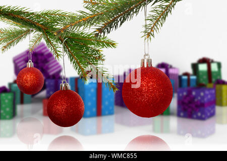 Baubles on tree against many colourful christmas gift boxes Stock Photo