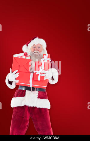 Santa carries a few presents against red background Stock Photo - Alamy