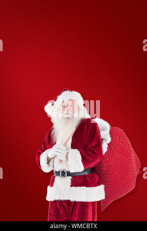 Santa carries his red bag against world map with compass showing europe ...