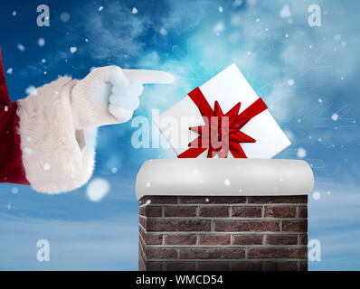 Santa Claus points at something against blue sky Stock Photo
