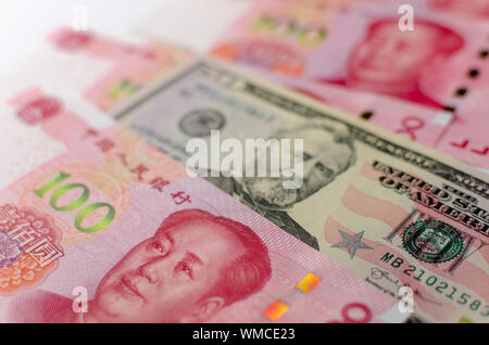 Chinese 100 Yuan banknotes and American 50 dollar bill between them. Close up image of currency of China and United States. Stock Photo