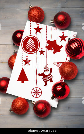 Hanging red christmas decorations against pale grey wooden planks Stock Photo