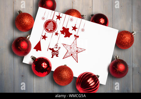 Hanging red christmas decorations against pale grey wooden planks Stock Photo