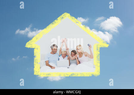 Family using a laptop in bed against cloudy sky Stock Photo