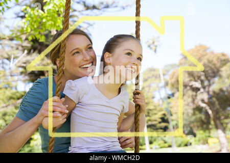 House outline against happy mother swinging daughter at park Stock Photo