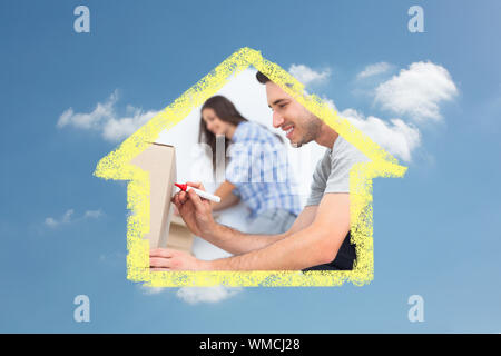 Man writing with a red marker on a moving box against cloudy sky Stock Photo
