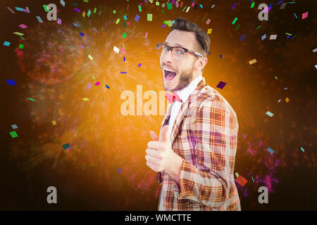 Geeky hipster pointing at camera against colourful fireworks exploding on black background Stock Photo
