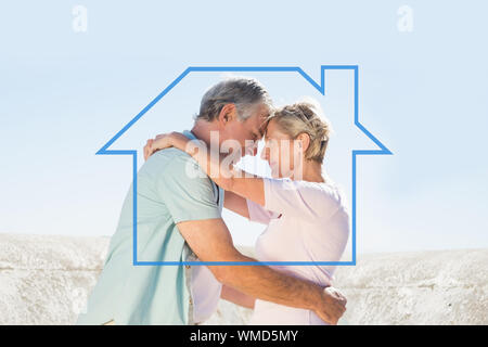 Happy senior couple embracing on the pier against house outline Stock Photo