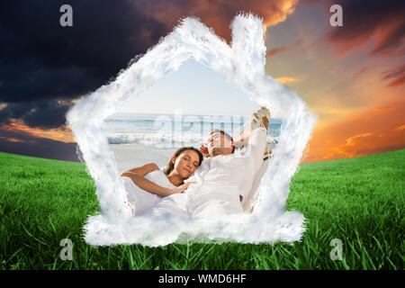 Calm couple napping in a hammock against green field under orange sky Stock Photo