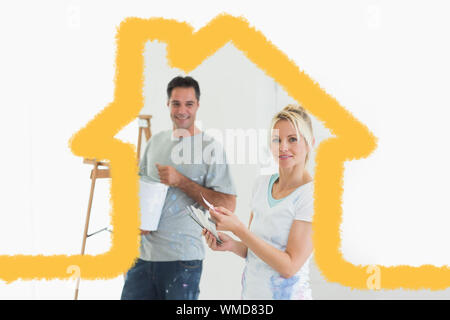 Couple with color swatches and ladder in a new house against house outline Stock Photo