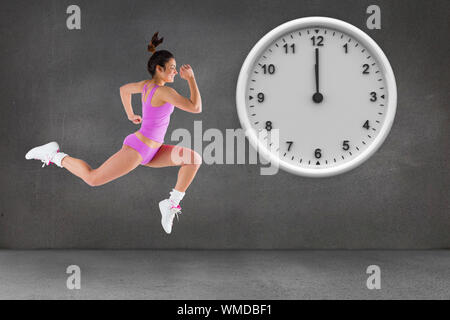 Composite image of fit brunette running against grey room Stock Photo