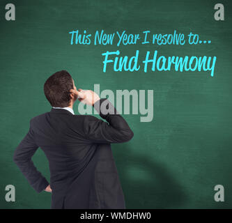 Thinking businessman scratching head against green chalkboard Stock Photo