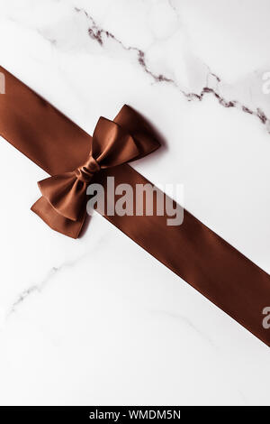 Black silk ribbon and bow on marble background, flatlay, Stock image