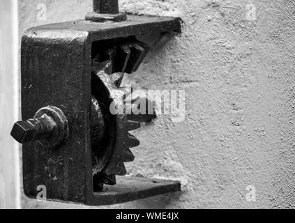 Black gear on the wall. Black and white, retro style photo Stock Photo