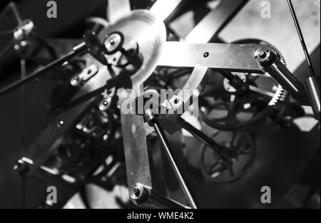 Vintage world clock mechanism, fragment with shiny cog wheels. Black and white, retro style photo Stock Photo