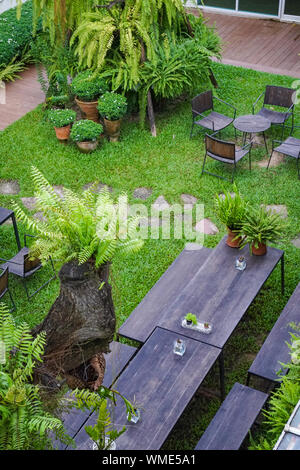 Public garden with wood chair and table on it decorate with little tree around. Stock Photo