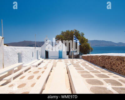Empty light terrace of old monastery with stone benches and white walls on sunny day Stock Photo