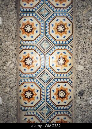 Close up shot of a wall decorated with tiles of various models. Stock Photo