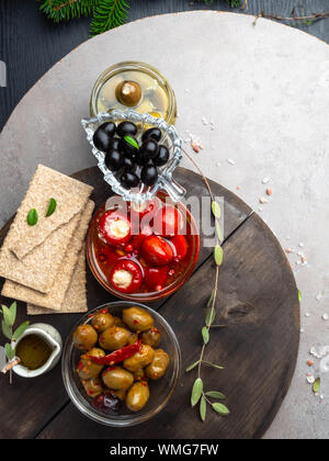 Italian food background, with bell peppers and green olives, stuffed with cheese, black olives, olive oil and green spruce or fir branch