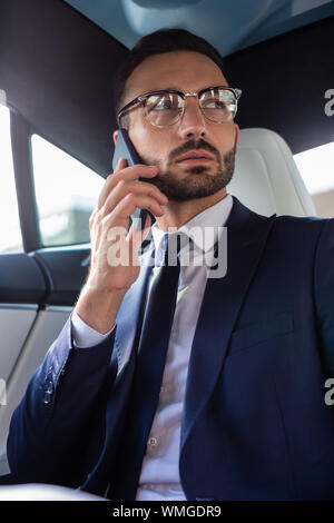 Stylish businessman wearing suit and tie calling his wife Stock Photo