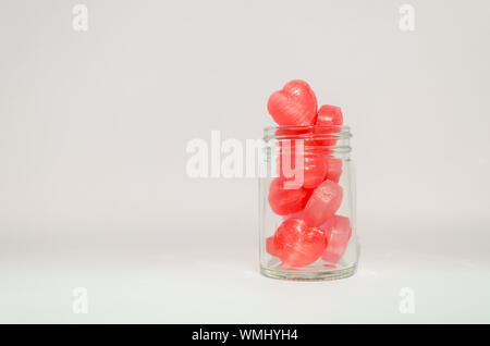 Red Candies In Jar Against White Background
