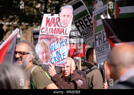 London, UK. September 5th, 2019.  Pro Palestinian supporters in London rally across 10 Downing Street to protest the visit of Israeli leader.  Hundreds gatherer with signs and flags denouncing both leaders impromptu meeting under heavy police surveillance. Pro Palestine supporter with a War Criminal sign with Netanyahu. Credit: Alamy Live News. Stock Photo