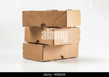 close-up view of cardboard boxes on white background - stacked small brown cardboard boxes Stock Photo