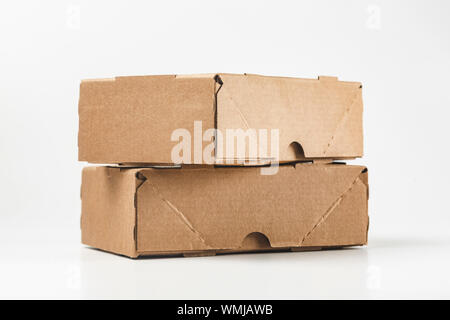 close-up view of cardboard boxes on white background - stacked small brown cardboard boxes Stock Photo