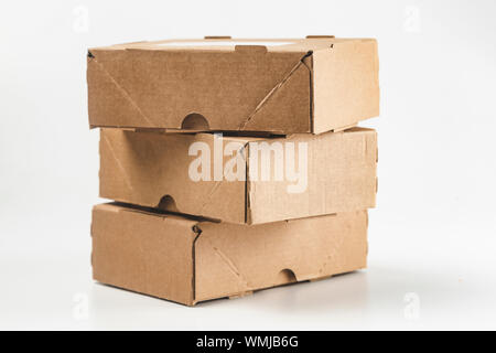 close-up view of cardboard boxes on white background - stacked small brown cardboard boxes Stock Photo