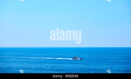 Panoramic view of the sea with small ship and clear blue sky Stock Photo