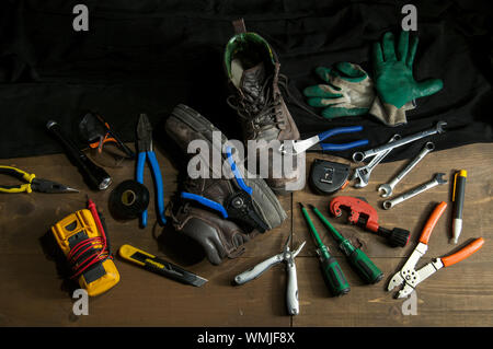 Electrician tools and gear on a workbench in a low key light photography Stock Photo