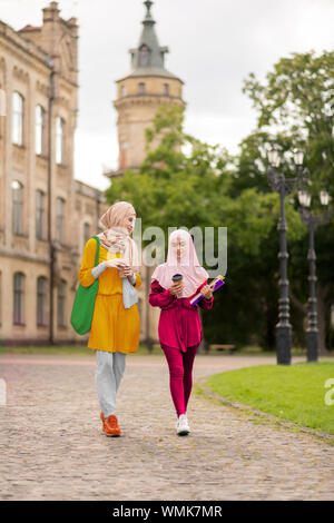 Young muslim women walking to university together Stock Photo