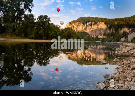 Roque-Gageac, Dordogne, France. Hot air balloons in the early morning float over the tufa cliffs and the dordogne river Stock Photo