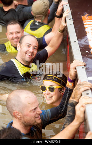 Contestants in the ‘Block Ness Monster’ obstacle at the Tough Mudder endurance event in Badminton Park, Gloucestershire UK Stock Photo