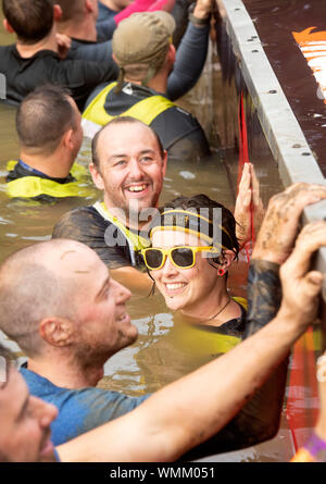 Contestants in the ‘Block Ness Monster’ obstacle at the Tough Mudder endurance event in Badminton Park, Gloucestershire UK Stock Photo