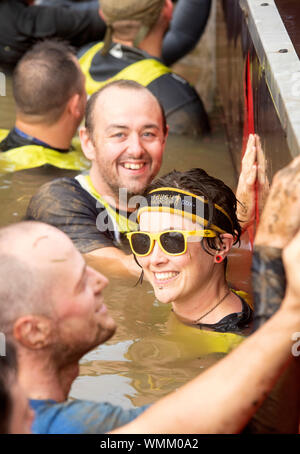 Contestants in the ‘Block Ness Monster’ obstacle at the Tough Mudder endurance event in Badminton Park, Gloucestershire UK Stock Photo