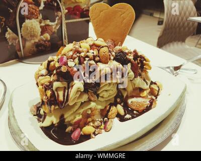 Close-up Of Ice Cream With Mixed Dry Fruits And Chocolate Sauce In Plate