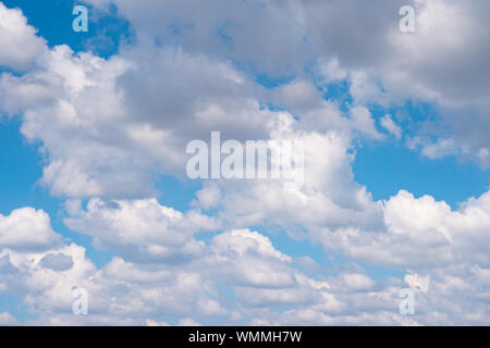 The blue sky with moving white clouds. The sky is a beautiful color shade suitable for use as a background image. Stock Photo