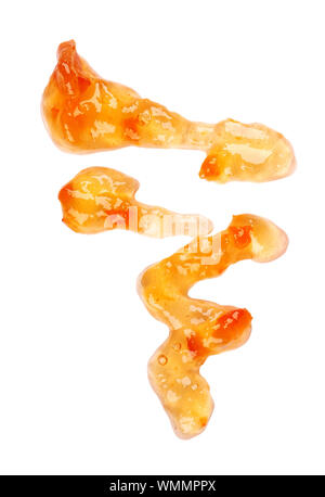 Orange thick jam drizzle, isolated on white background. Mandarin marmalade, sauce, topping drops. Top view. Stock Photo